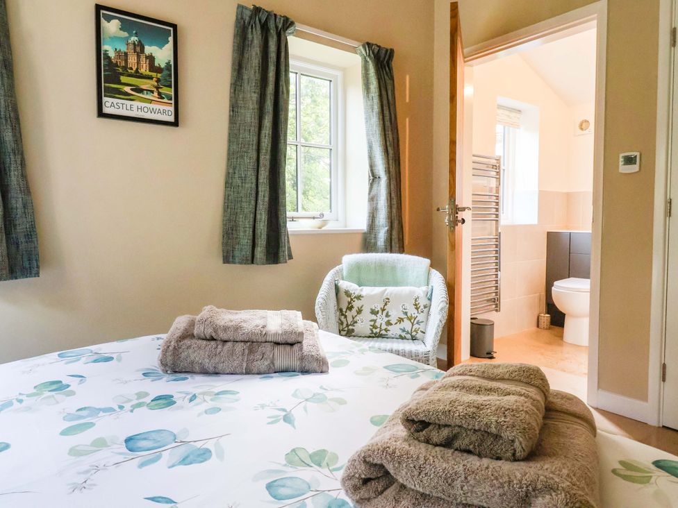 A bedroom with a bed and towels folded at Apple Tree Cottage in York