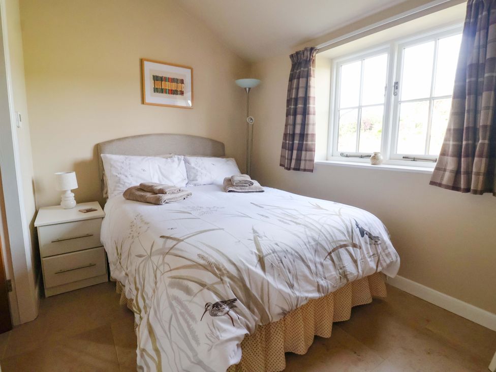 A bedroom with a bed and lamp at Apple Tree Cottage York