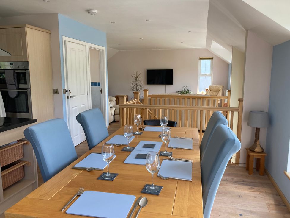 A dining room with a table set for meals at 1 Bryn Beudy in Narberth