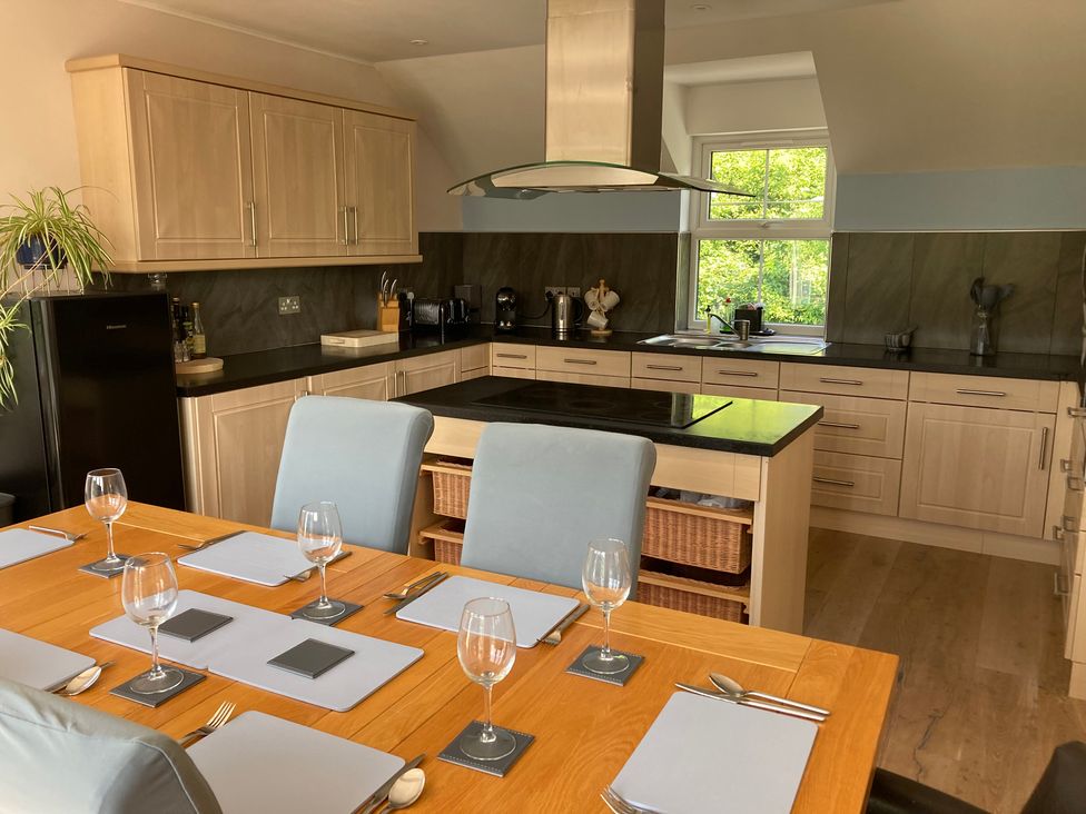 A kitchen with dining table and chairs at 1 Bryn Beudy in Narberth