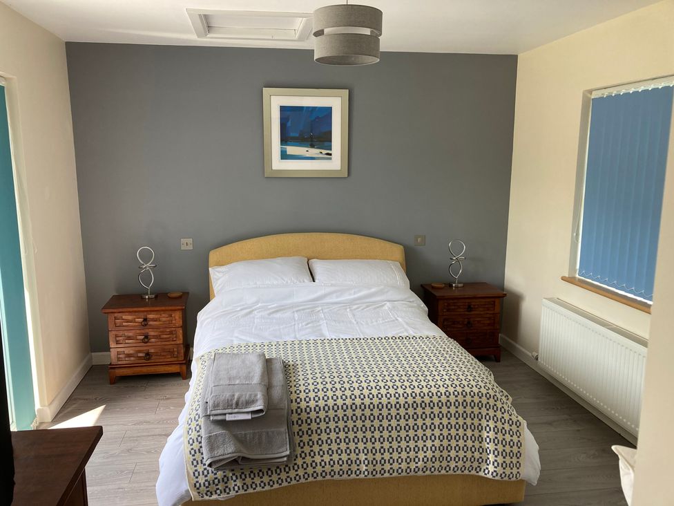 A bedroom with a bed and nightstands at 1 Bryn Beudy Narberth