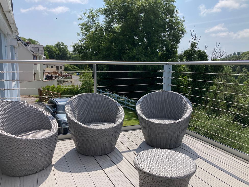 A balcony with outdoor chairs and a small table at 1 Bryn Beudy Narberth
