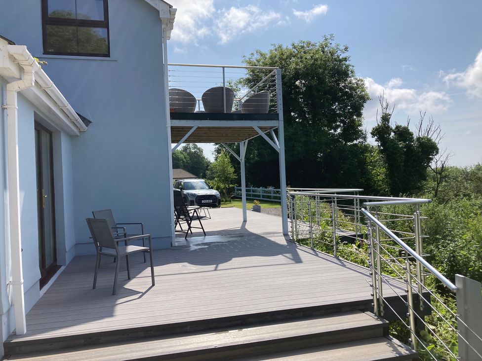 An outdoor patio with chairs and a table at 1 Bryn Beudy Narberth