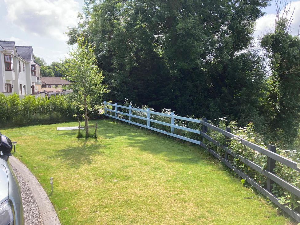 A garden with grass, a tree, and a fence at 1 Bryn Beudy Narberth