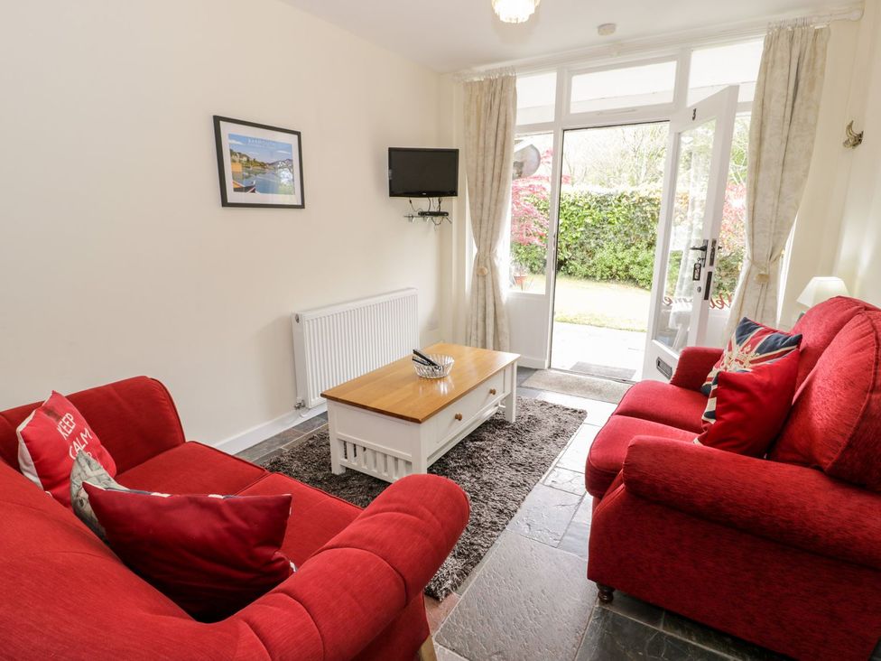 A living room with sofas and a table at 3 Riverside Bungalows in Llanbedr
