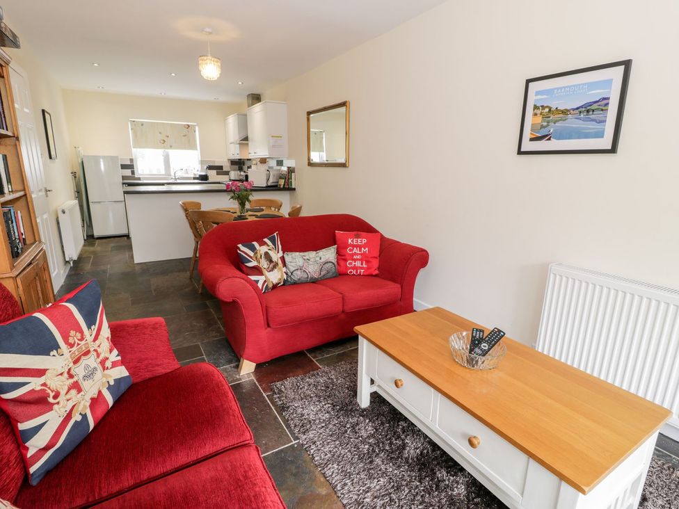 A living room with a red sofa and coffee table at 3 Riverside Bungalows in Llanbedr