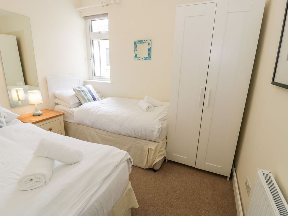 A bedroom with two beds and a wardrobe at 3 Riverside Bungalows Llanbedr