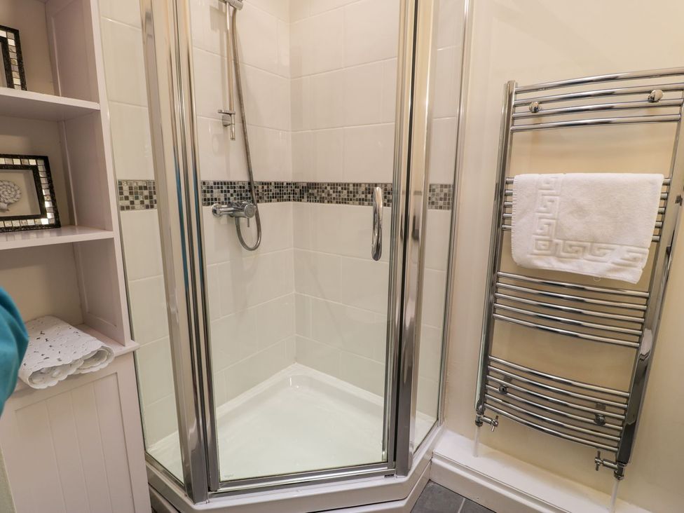 A shower stall with a towel rack in the bathroom at 3 Riverside Bungalows Llanbedr