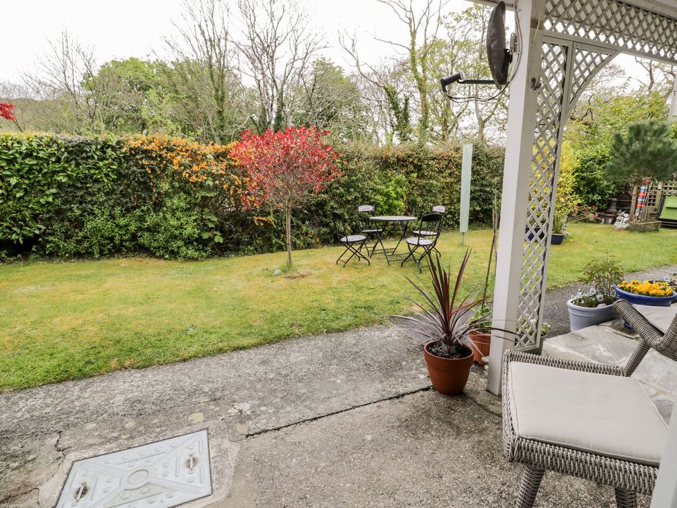 A garden with a table and chairs at 3 Riverside Bungalows Llanbedr
