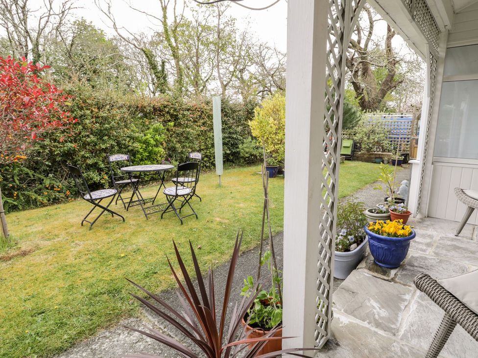 A garden with a table and chairs at 3 Riverside Bungalows in Llanbedr