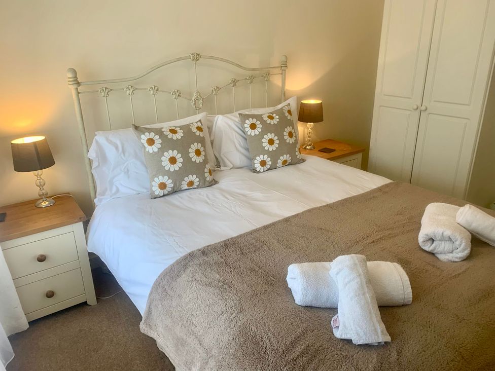 A bedroom with a double bed and bedside table at 3 Riverside Bungalows Llanbedr