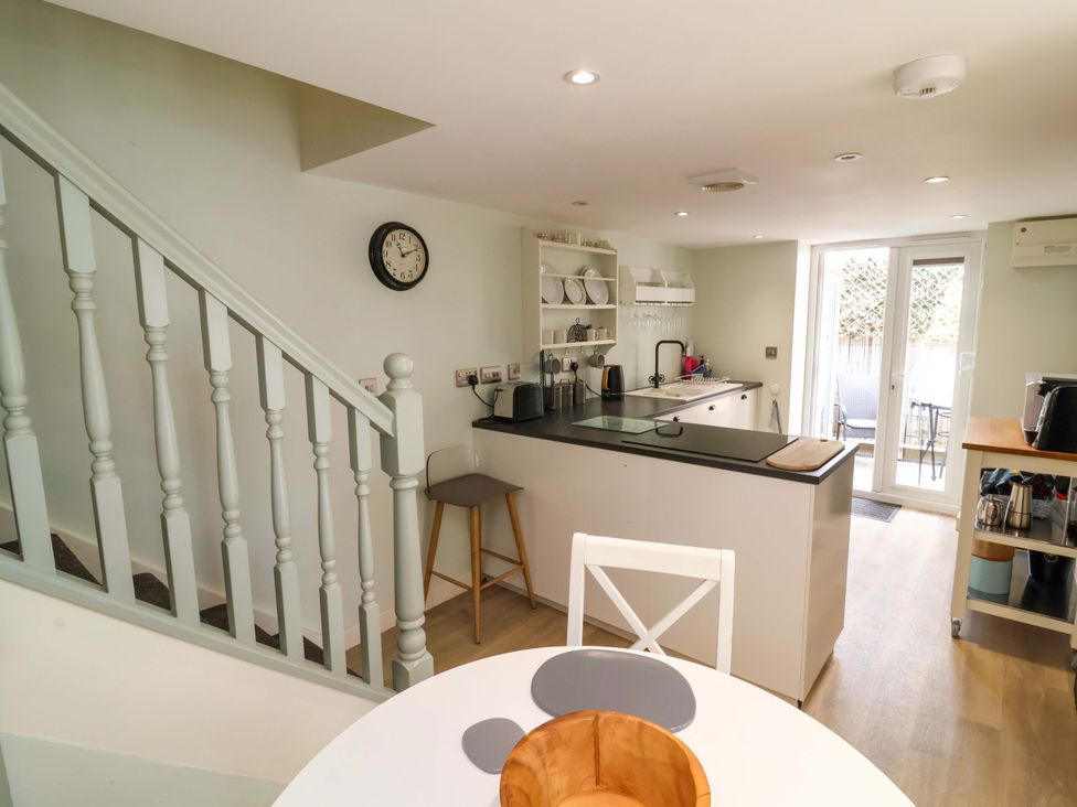 A kitchen with a clock and a dining area at Sea Sanctuary 
