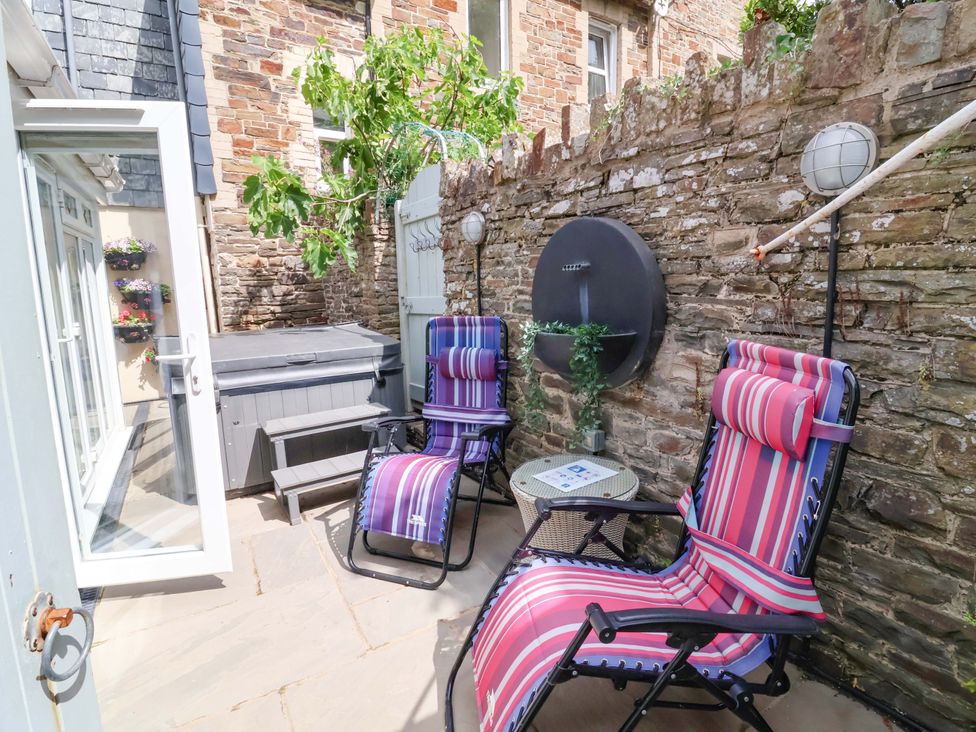 An outdoor seating area with chairs, a hot tub, and plants at Sea Sanctuary in 