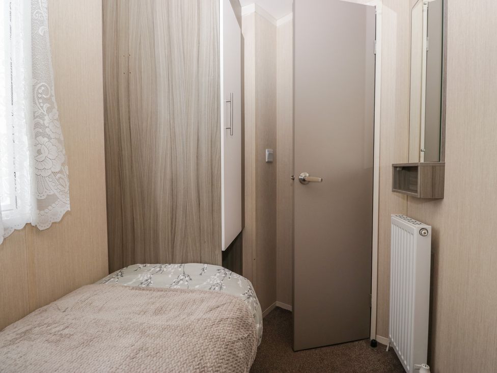 A bedroom with a bed, wardrobe, and mirror at Pinewood in Kidlington
