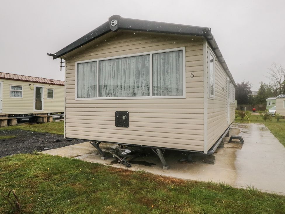 A caravan with large windows and a concrete base at Pinewood in Kidlington