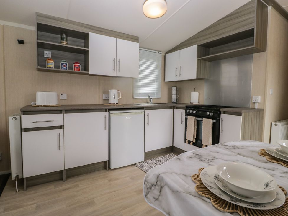 A kitchen with cabinets, a sink, and an oven at Pinewood in Kidlington