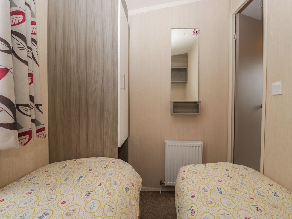 A bedroom with two beds and a mirror at Pinewood in Kidlington