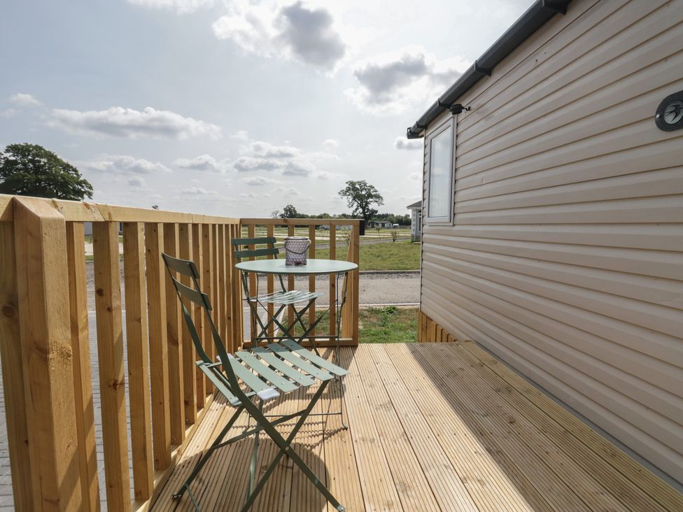 A deck with a table and chair at Pinewood in Kidlington