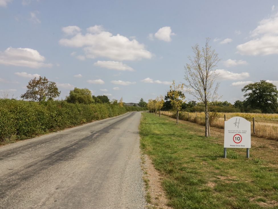 A road with a sign and trees at Heathfield Park in Kidlington