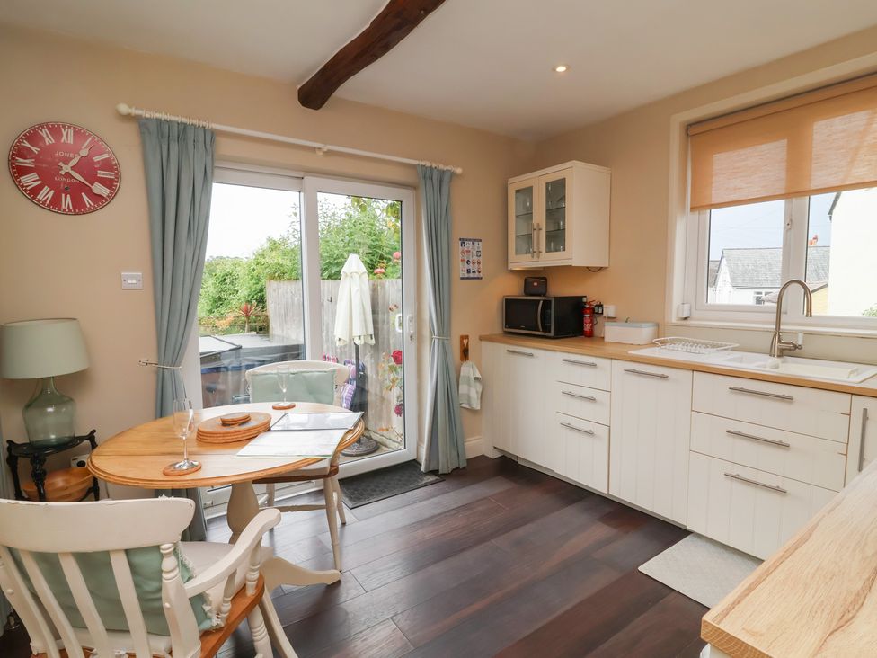 A kitchen with a table and chairs at Quay Close Cottage