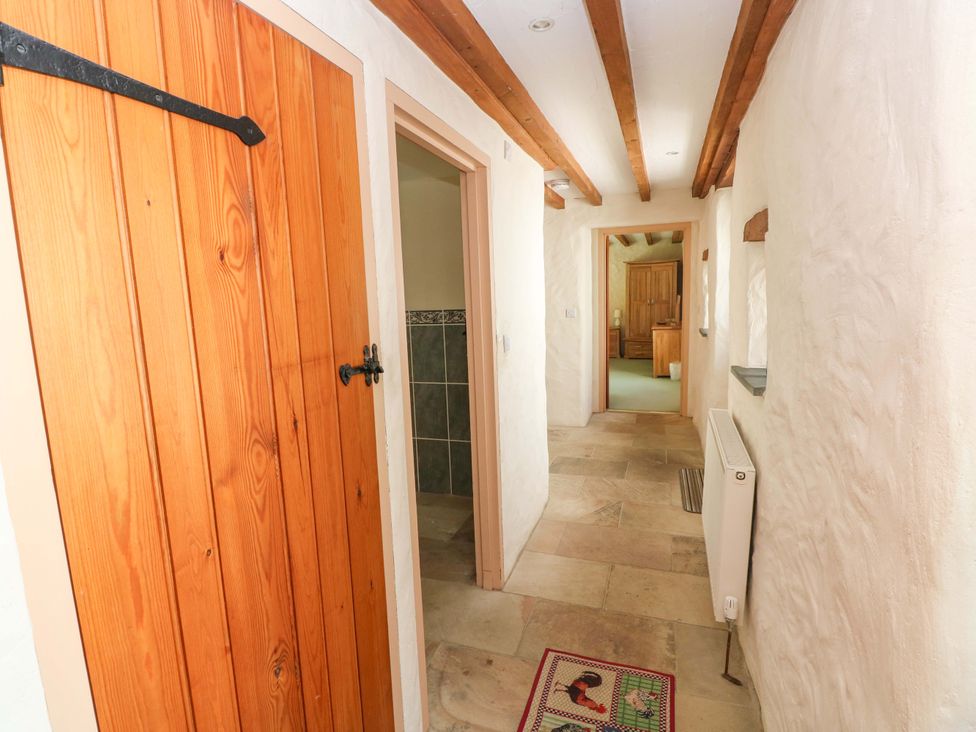 A hallway with wooden doors and tiled flooring at Carreg Las in Haverfordwest