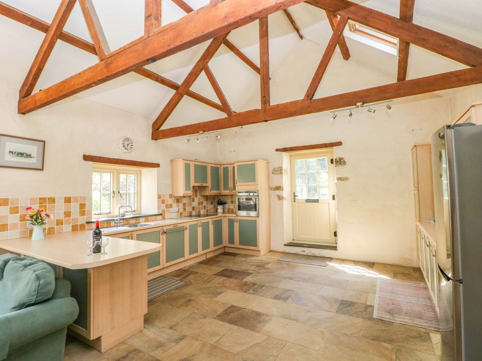 A kitchen with a sink, refrigerator, and oven at Carreg Las in Haverfordwest