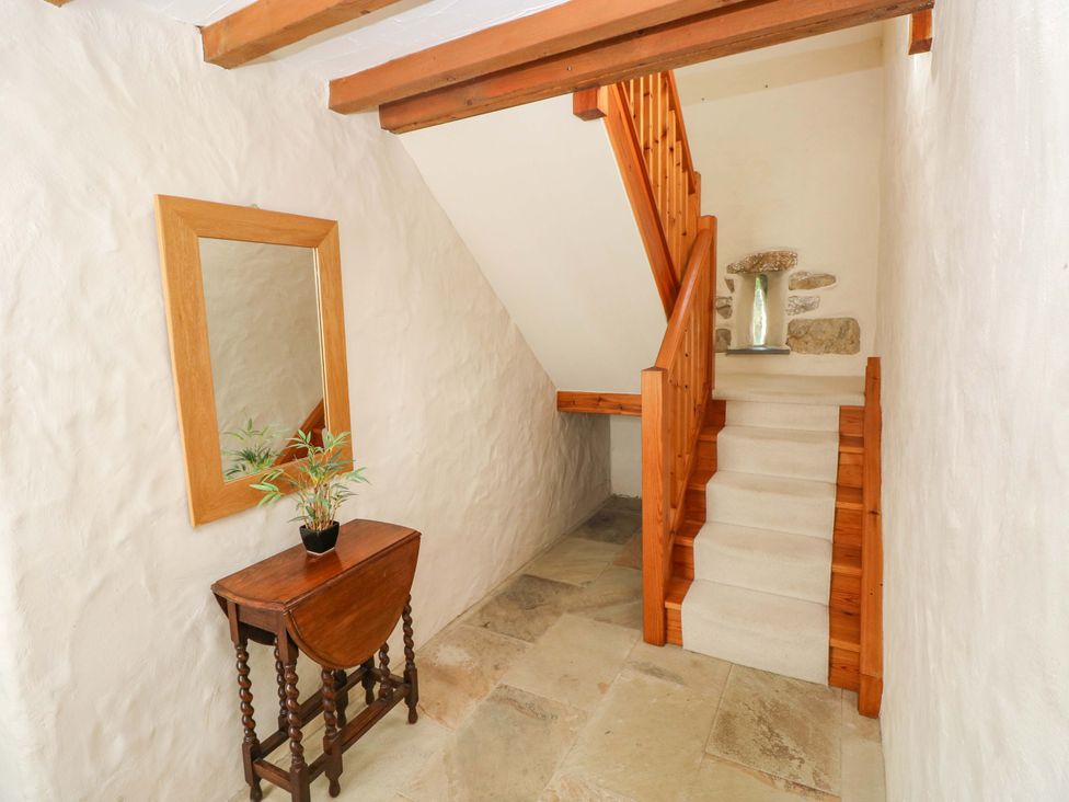 A hallway with a staircase and a mirror at Carreg Las in Haverfordwest