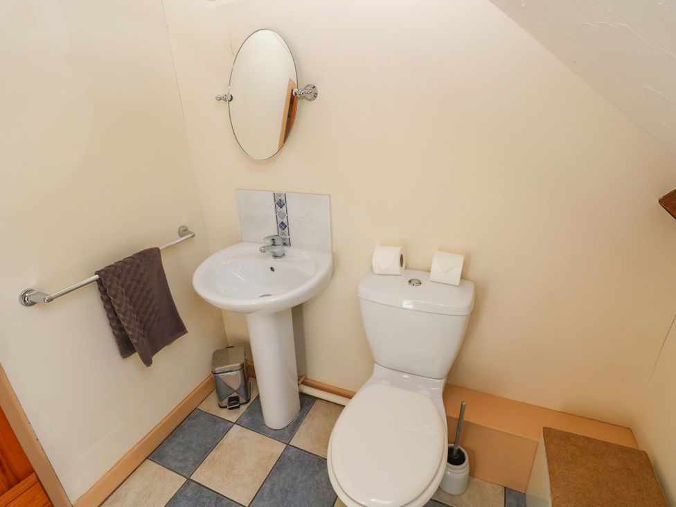 A bathroom with a sink and toilet with a mirror at Carreg Las Haverfordwest