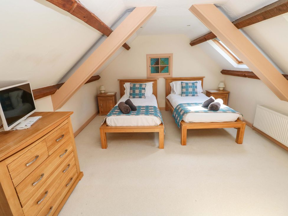 A bedroom with two beds and a dresser at Carreg Las in Haverfordwest