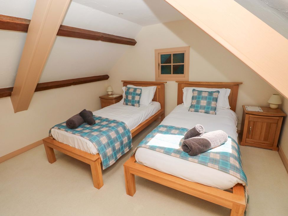 A bedroom with two single beds and a window at Carreg Las Haverfordwest