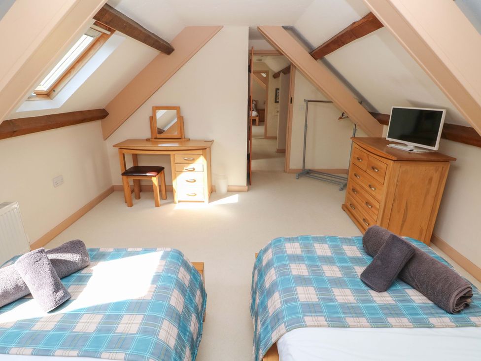 A bedroom with two beds and a desk at Carreg Las in Haverfordwest