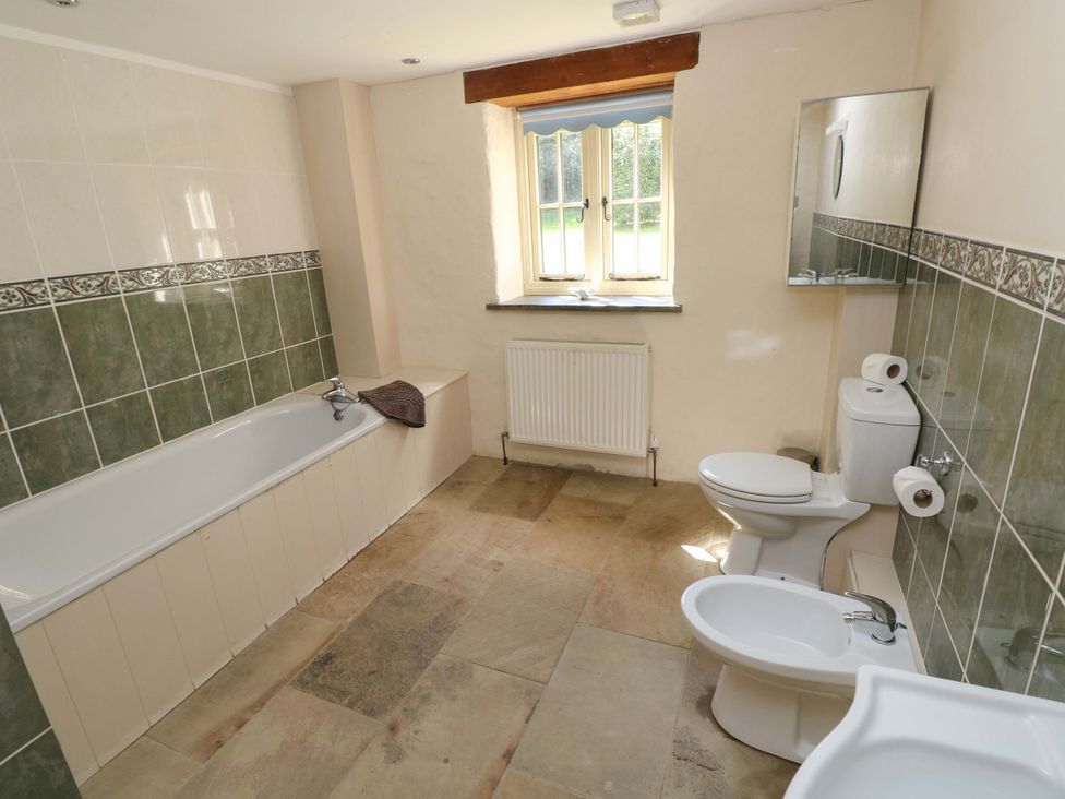 A bathroom with a bathtub, toilet, bidet and sink at Carreg Las in Haverfordwest