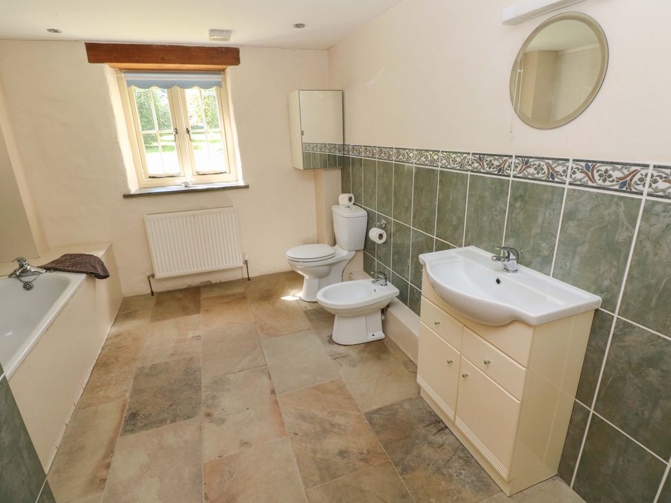A bathroom with a bathtub, toilet, sink, and bidet at Carreg Las in Haverfordwest