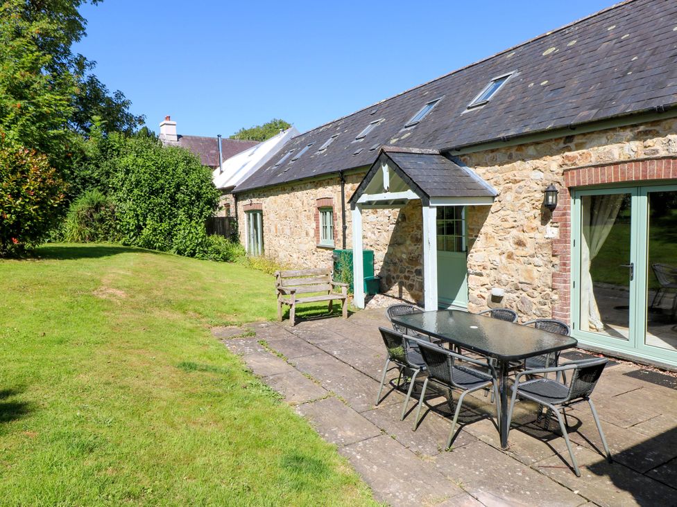 A garden area with a stone wall, table and chairs at Carreg Las Haverfordwest