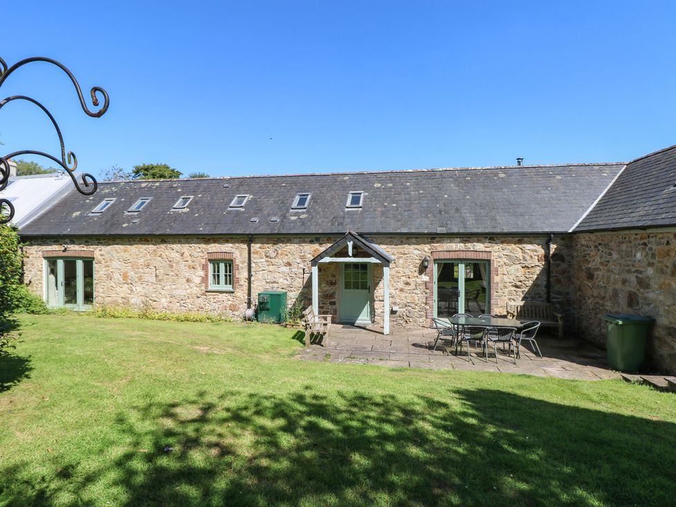 A garden with stone wall and patio furniture at Carreg Las in Haverfordwest