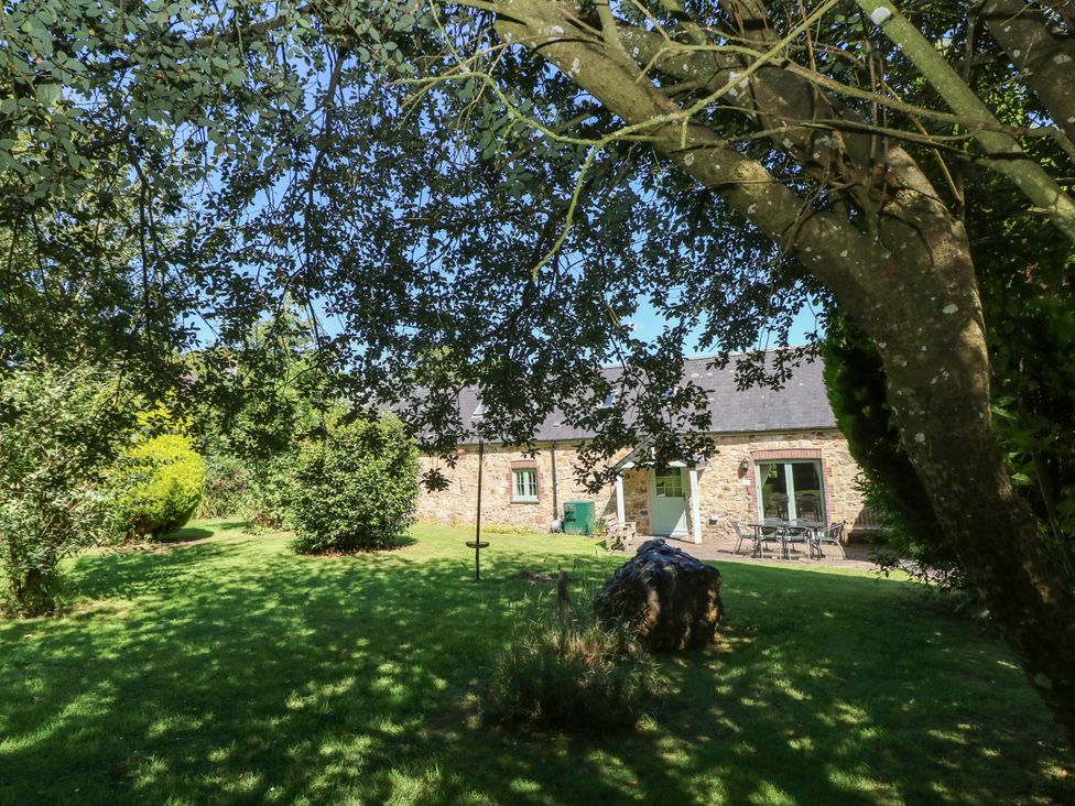 A stone house with furniture in a garden at Carreg Las in Haverfordwest
