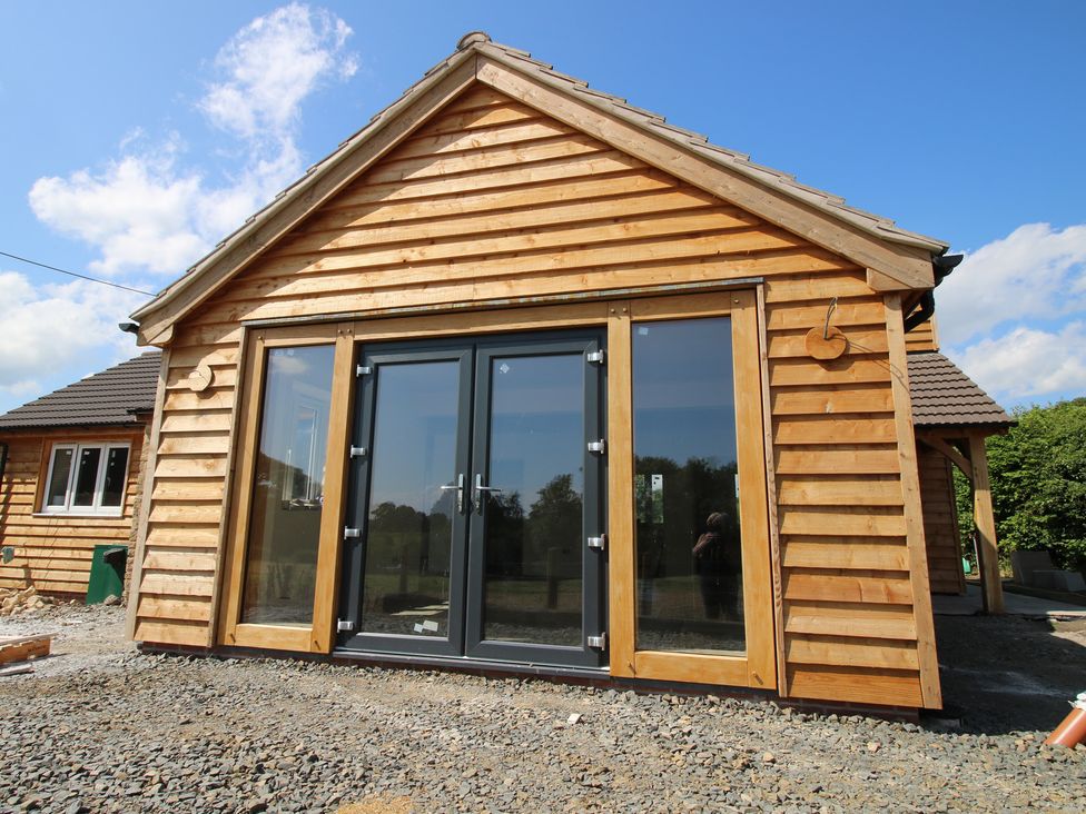 A wooden structure with glass doors and gravel at Dingle in Kidderminster