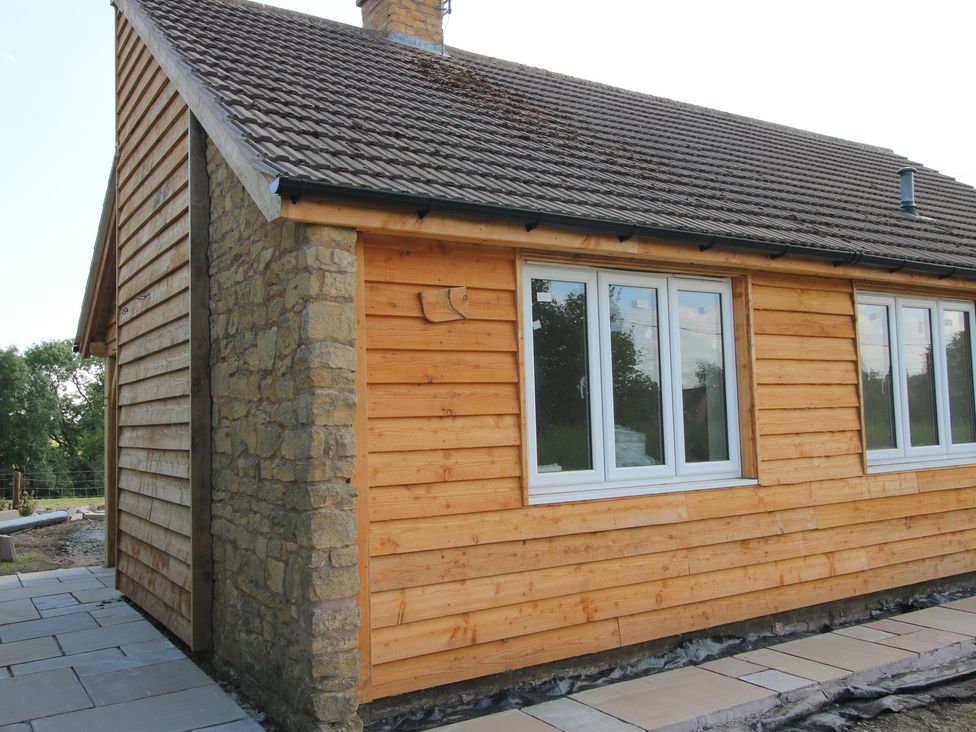 A house with wooden cladding and stone wall outside Dingle Kidderminster