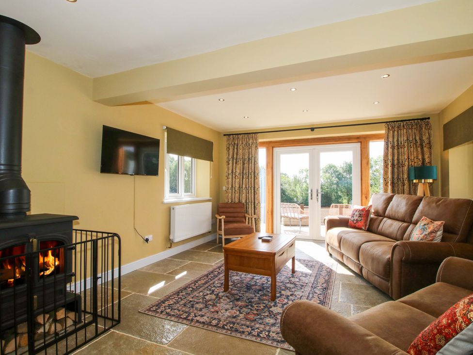 A living room with a fireplace and television at Dingle Cleobury Mortimer