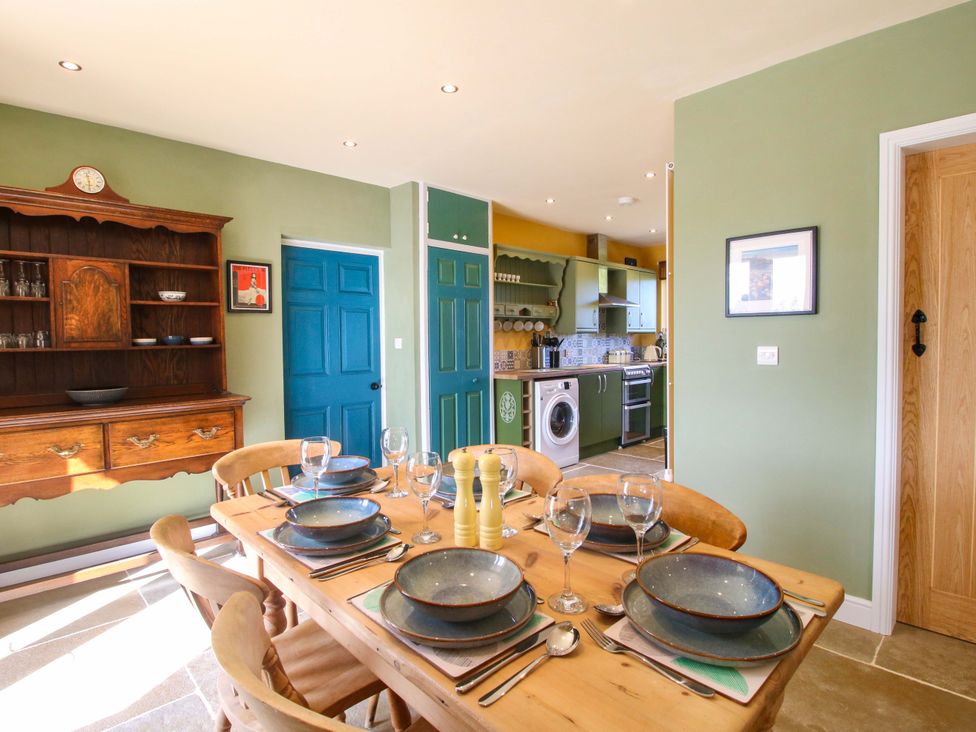 A kitchen with dining table and wooden shelves at Dingle, Cleobury Mortimer