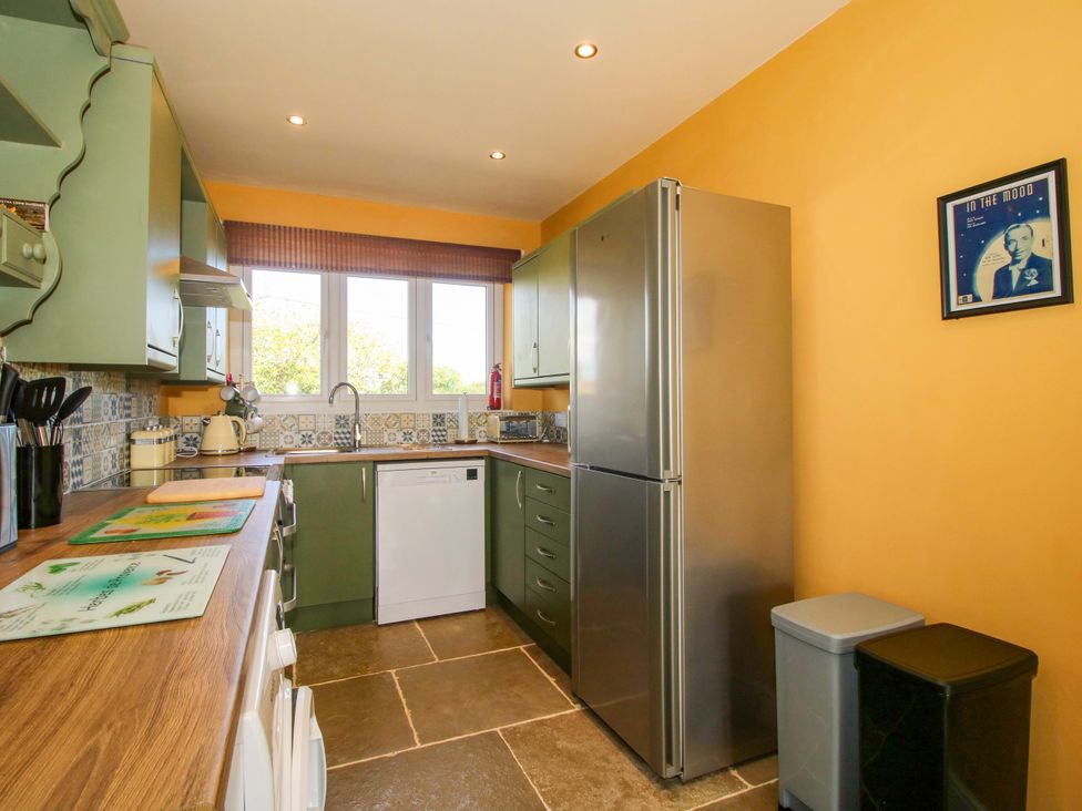 A kitchen with a refrigerator and dishwasher at Dingle in Cleobury Mortimer