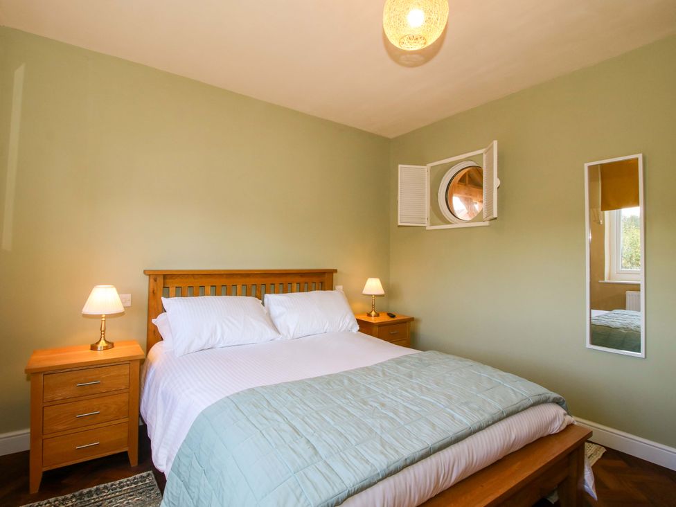 A bedroom with a bed and nightstand at Dingle in Cleobury Mortimer