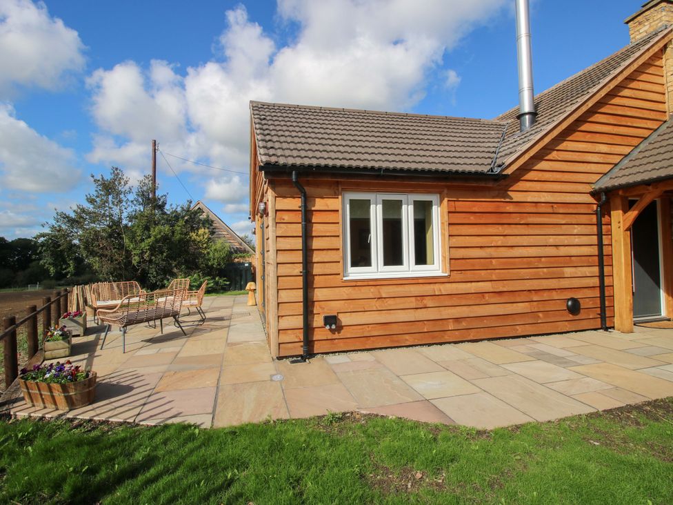 A house with a patio area and outdoor furniture at Dingle in Cleobury Mortimer