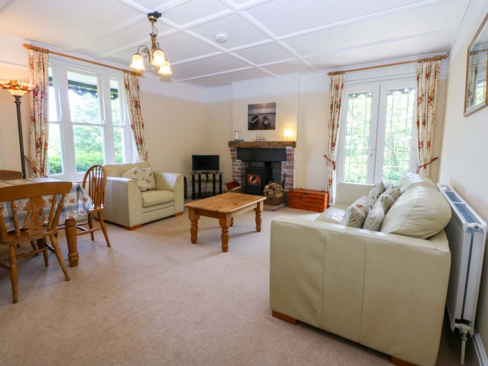 A living room with a sofa and dining table at Disgwylfa Sarn Mellteyrn