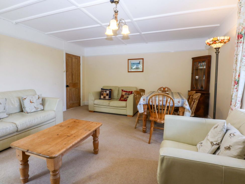 A living room with sofas and a dining table at Disgwylfa in Sarn Mellteyrn