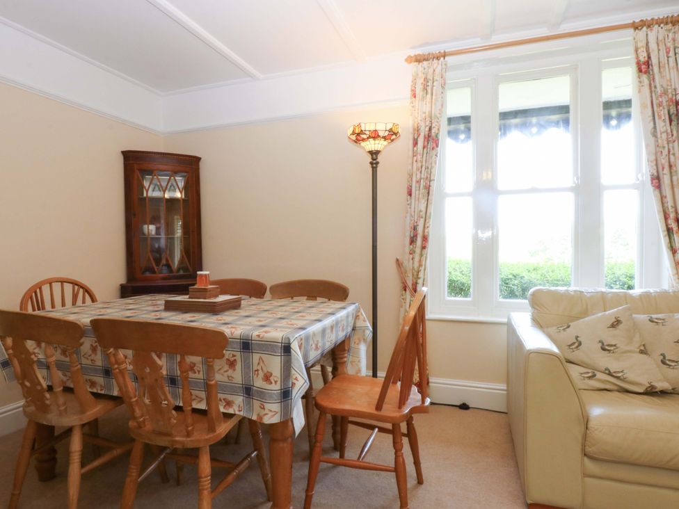 A dining room with a table and chairs at Disgwylfa in Sarn Mellteyrn