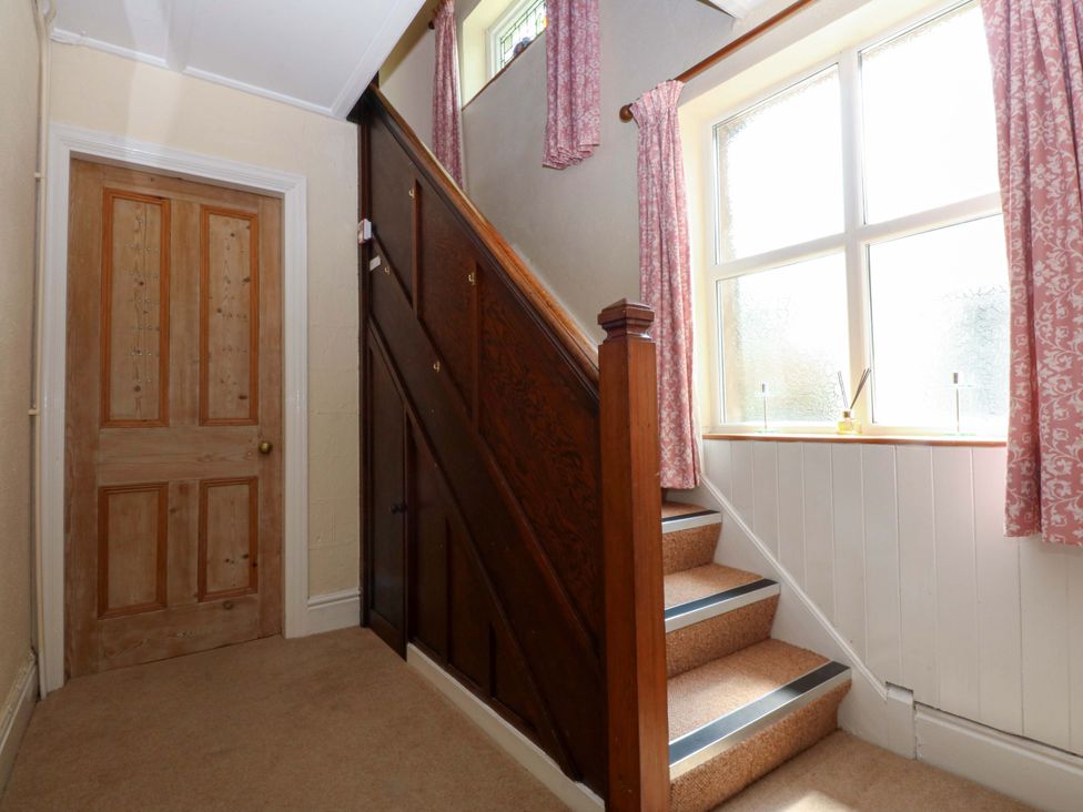 A hallway with a door and staircase at Disgwylfa in Sarn Mellteyrn