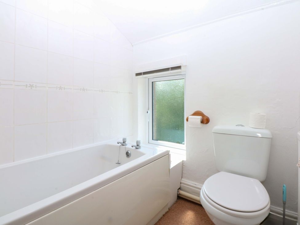 A bathroom with a bathtub and toilet at Disgwylfa Sarn Mellteyrn