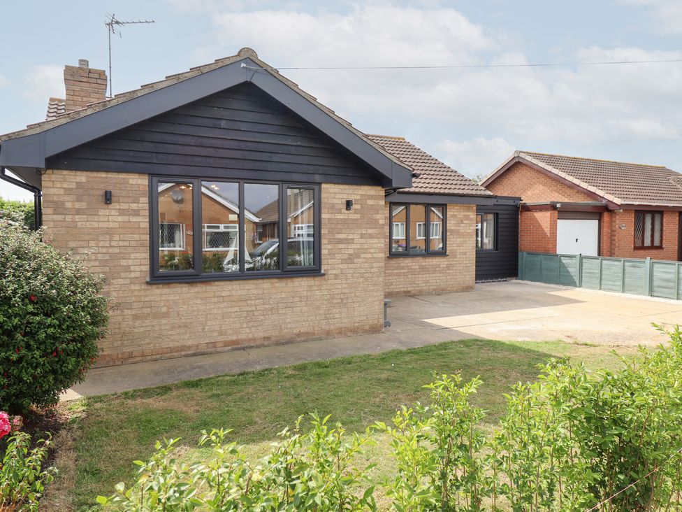 A house with a brick exterior and garden at Sandy Toes in Trusthorpe