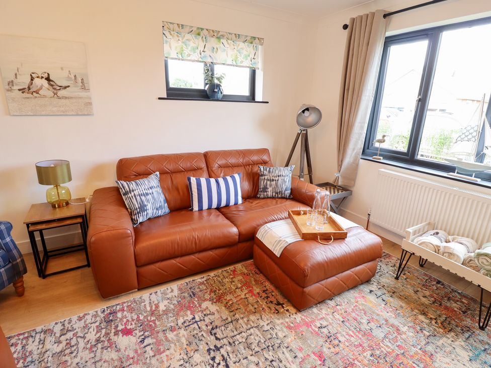 A living room with a sofa and coffee table at Sandy Toes in Trusthorpe